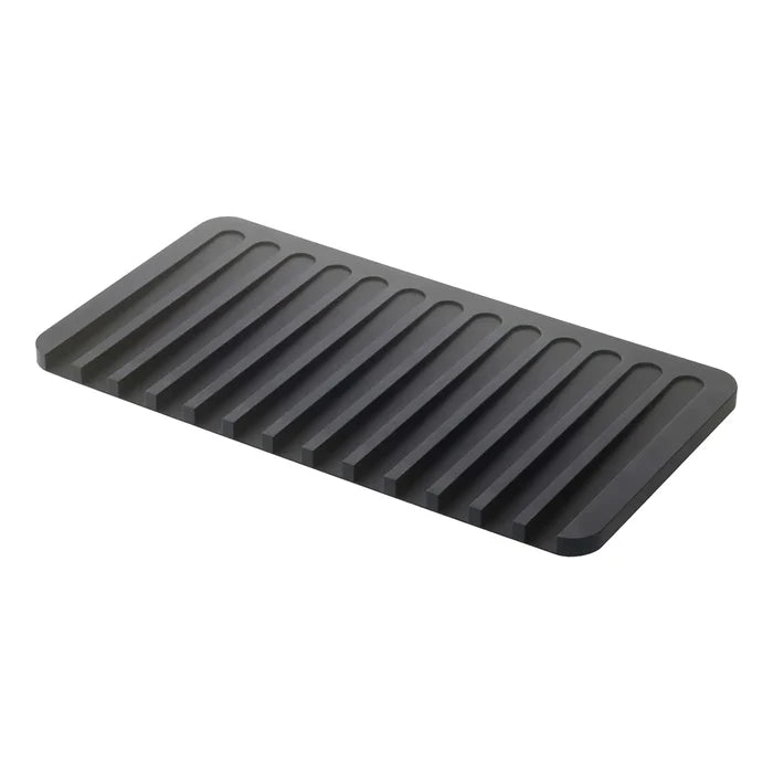 A dark gray rectangular mat with parallel raised ridges, shown at an angle on a plain white background.
