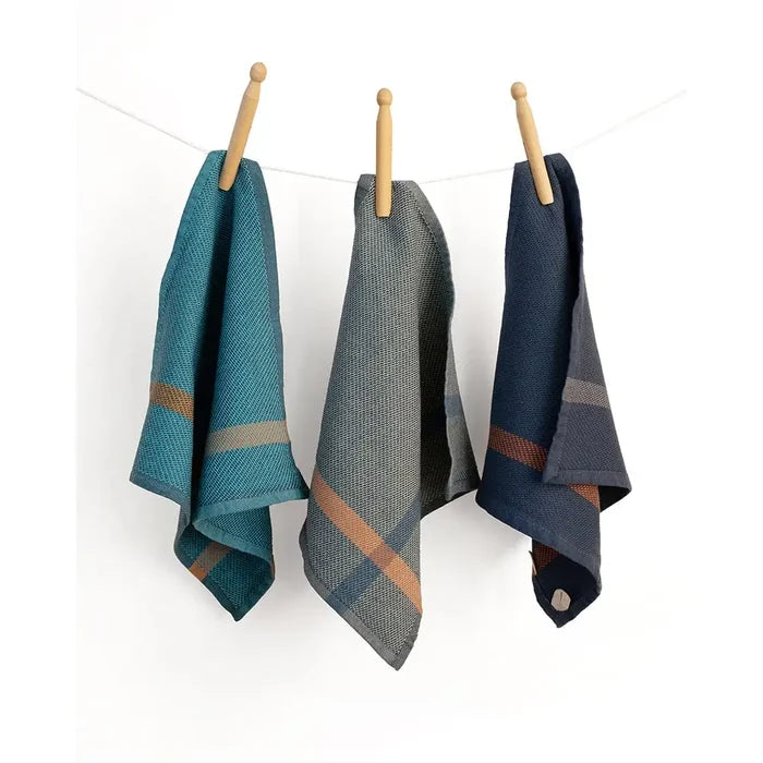 Three plaid towels hanging on a line against a white background