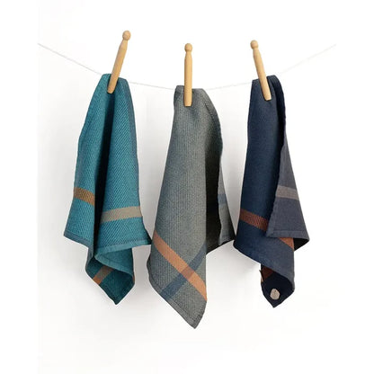 Three plaid towels hanging on a line against a white background