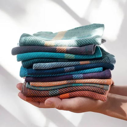 Stack of colorful fabric swatches held in a hand against a white background