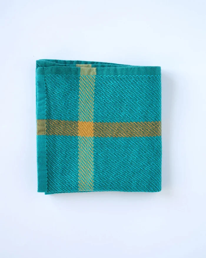 Teal fabric with gold cross pattern on a white background