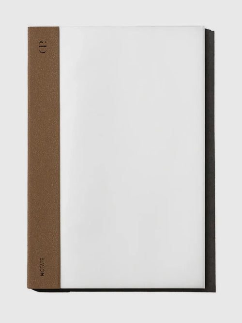 A notebook with a white page area and a textured brown spine band, photographed on a light gray background.