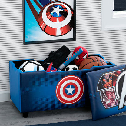 An Avengers-themed upholstered storage bench for kids, featuring character logos and images on the backrest, placed in a room with a decorated wall and various children's toys.