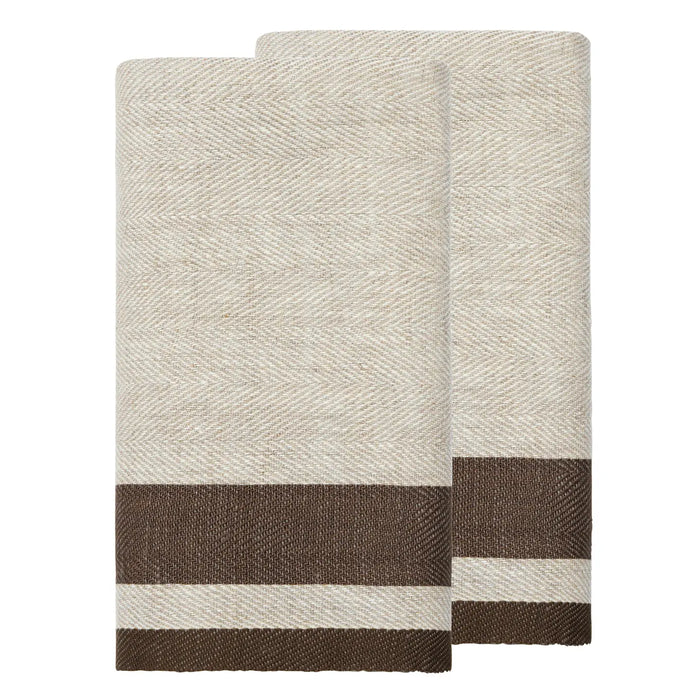 Two folded woven towels in a light beige and white herringbone pattern with a contrasting dark brown stripe near the bottom, displayed on a solid white background.