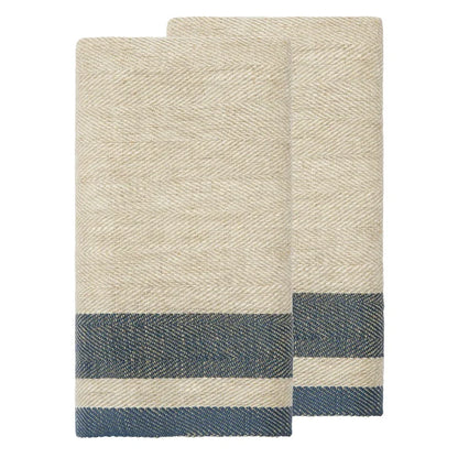Two folded woven towels in a natural beige color with a herringbone pattern and a navy blue striped border near the bottom, shown on a plain white background.