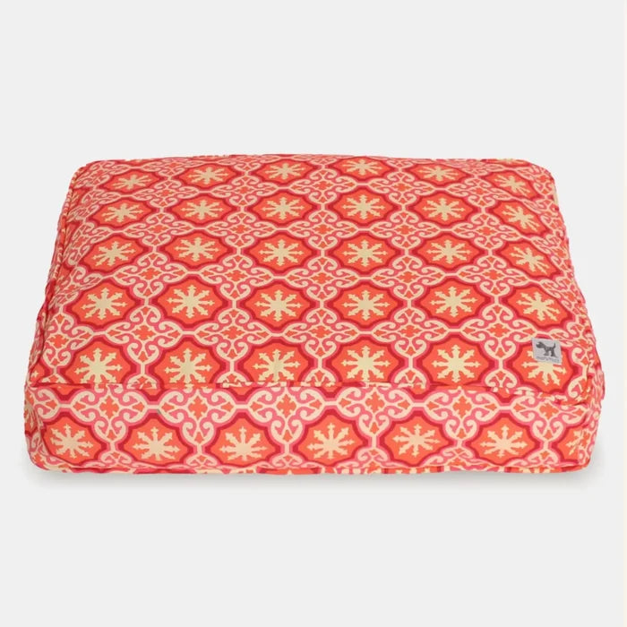 Red and yellow patterned pet bed on a white background