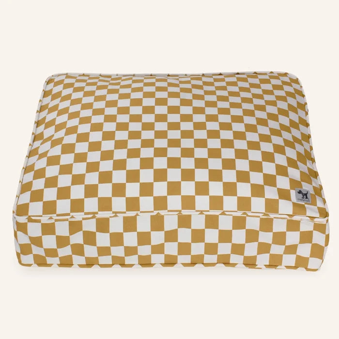 Checkered pet bed with mustard and white pattern on a white background