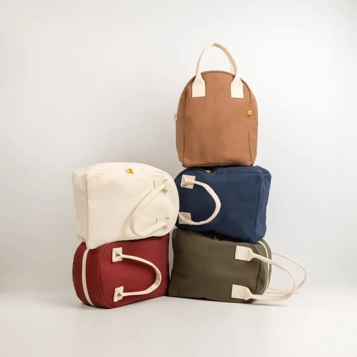 Five fabric bags in different colors stacked on a white background