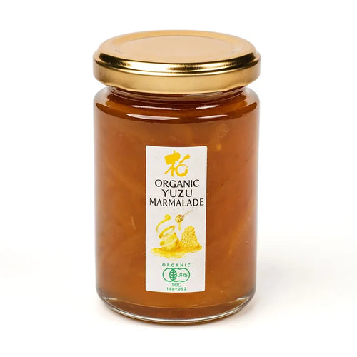 Jar of organic yuzu marmalade with a gold lid on a white background