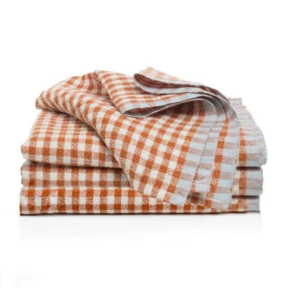 Stack of orange and white checkered towels on a white background